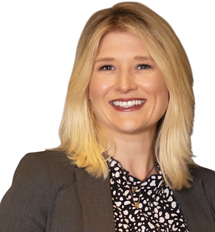 Christy M. Feldman, with shoulder-length blonde hair, smiles warmly in a gray blazer over a patterned shirt.