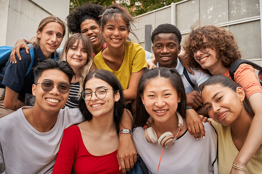 Selfie of a group of students looking at the camera smiling. Happy to be back to school.