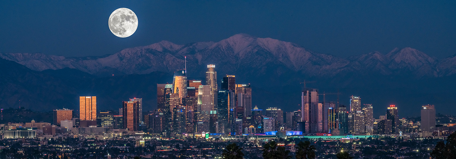 Moon over downtown Los Angeles with city lights.