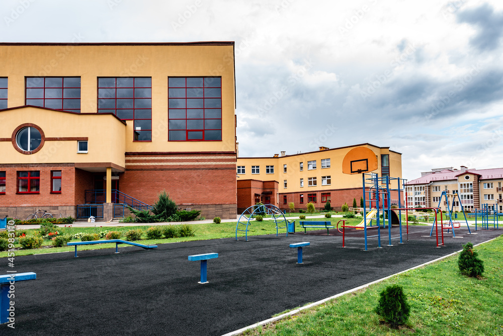 Exterior view of modern public school building with playground.