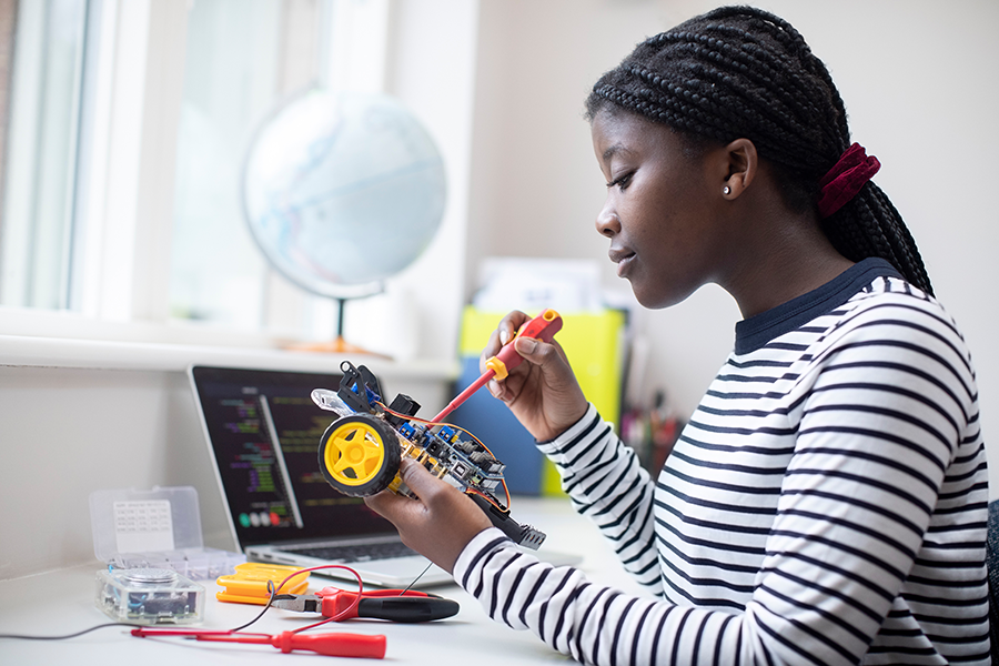 Female Teenage Pupil Building Robot Car In Science Lesson