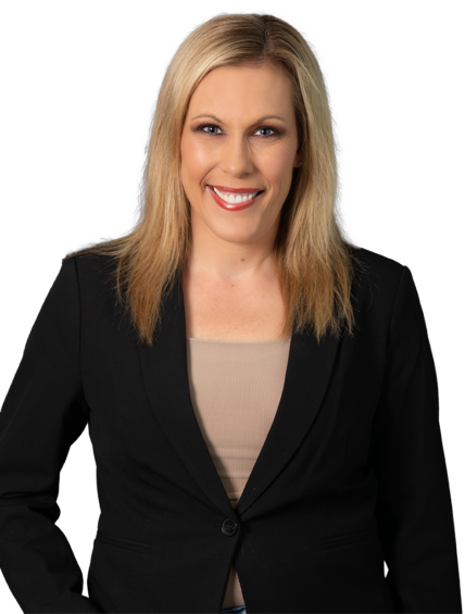 Blonde woman in a black blazer over a beige top, smiling against a dark blue patterned background.