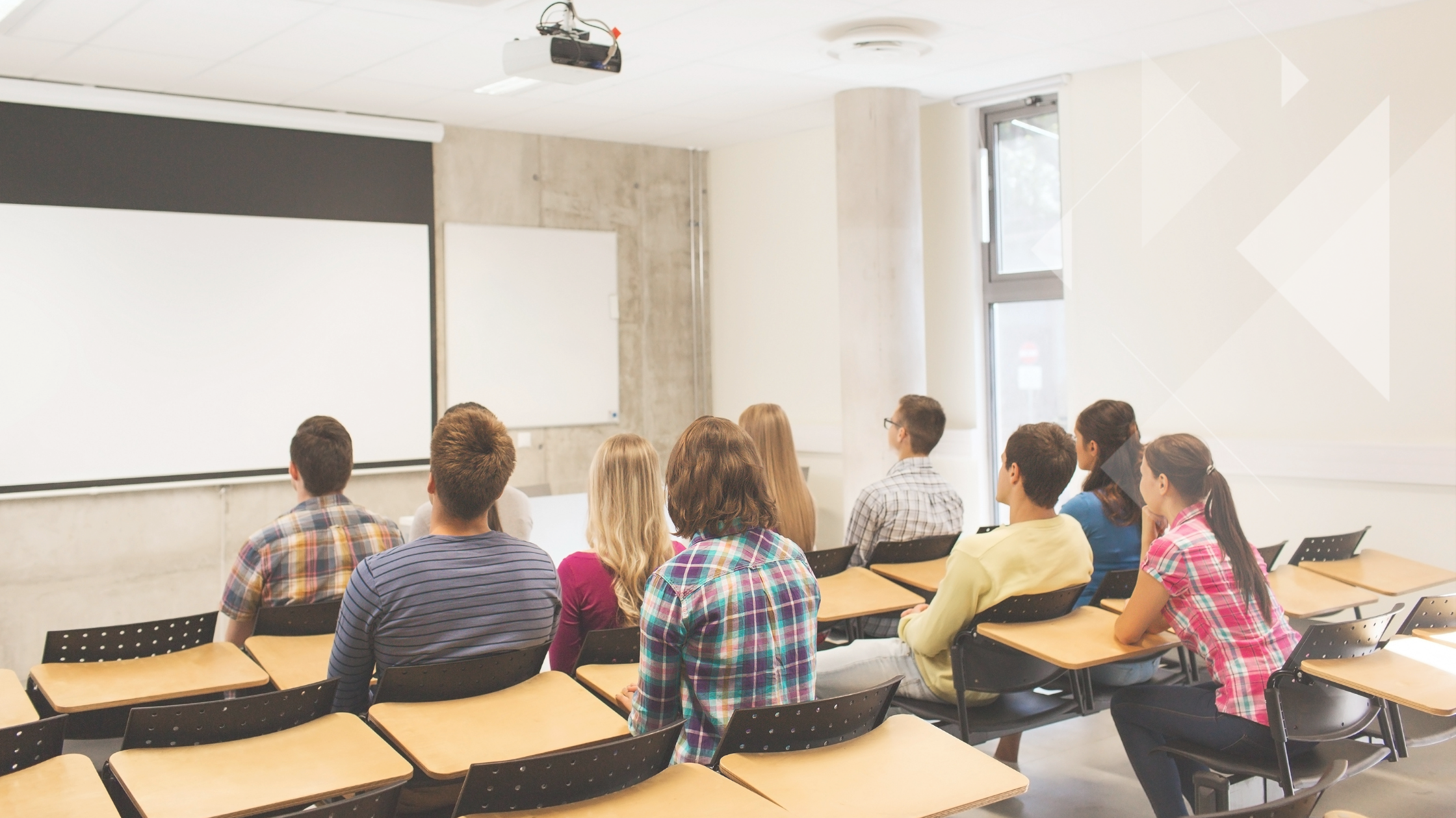 A group of students in a classroom, focused intently on the blank projection screen at the front, are immersed in planning future goals as part of their school's executive leadership succession program.