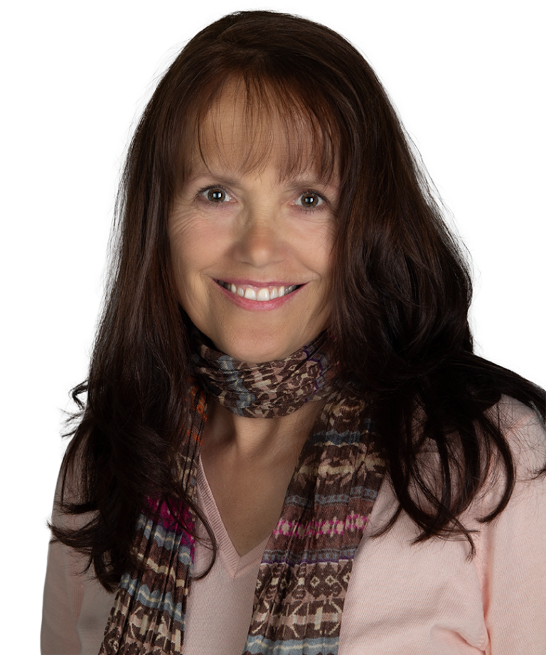 Farrell Scott, a smiling woman with long brown hair, wearing a patterned scarf and a light pink top, poses against a plain background.