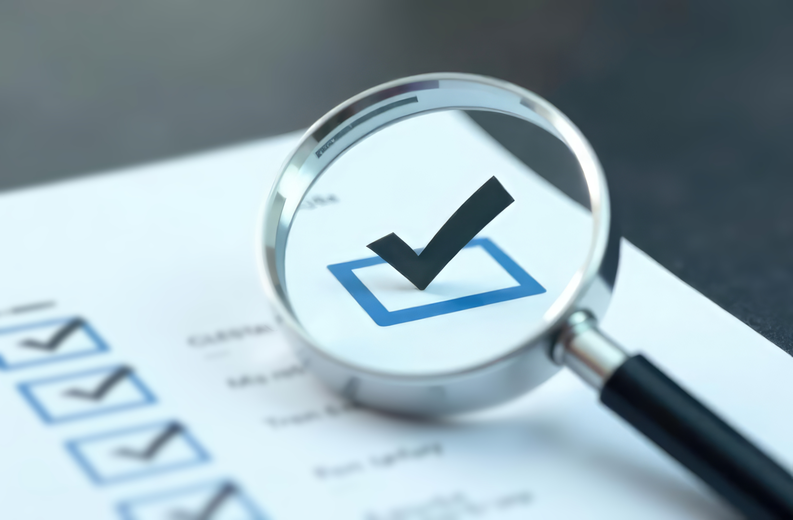 A magnifying glass focuses on a large check mark in a box on a CalSTRS checklist, highlighting successful completion or approval.